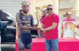 Cheddi Jagan Memorial Road Race 1st stage winner Briton John collecting trophy from Minister Deodat Indar