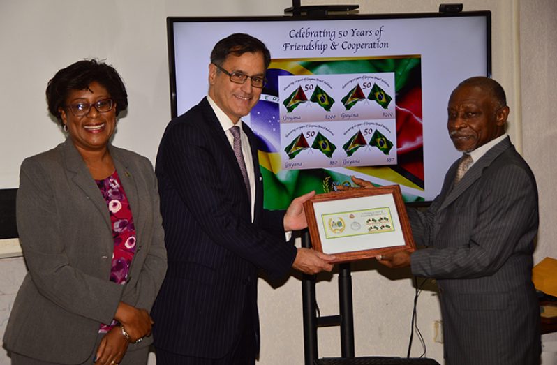 Minister of Foreign Affairs, Mr. Carl Greenidge (right) and Embassy of Brazil Deputy Head of Mission, Mr. Paul Silos with replicas of the stamp. To their left is Minister of Public Telecommunication, Ms. Cathy Hughes (Photo by Adrian Narine)