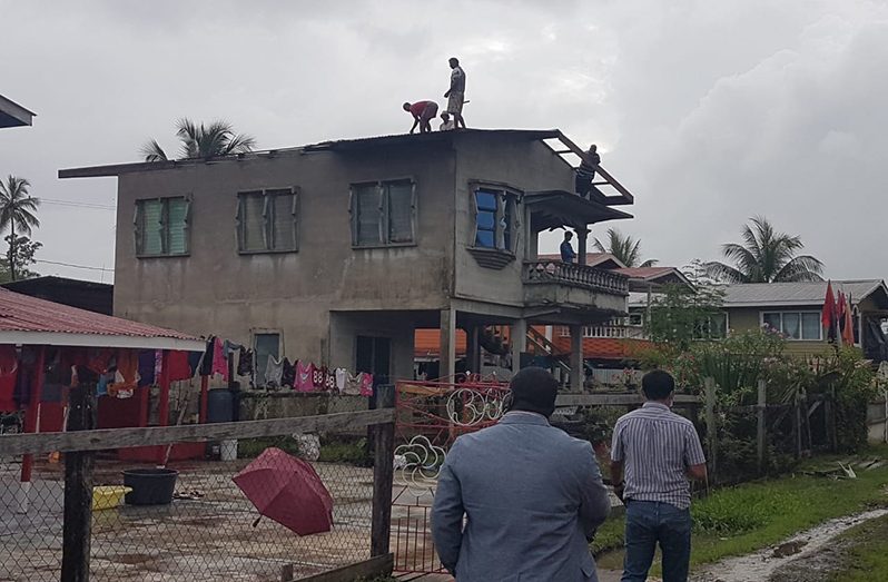 Persons repairing the roof of one of the damaged properties