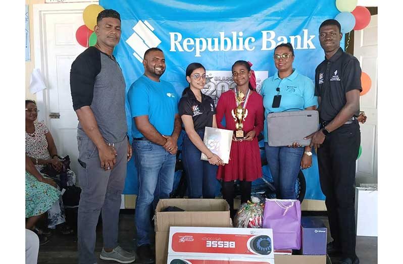 Top Student Damali Ramdial receives her prizes from staff of Republic Bank in the presence of her parents
