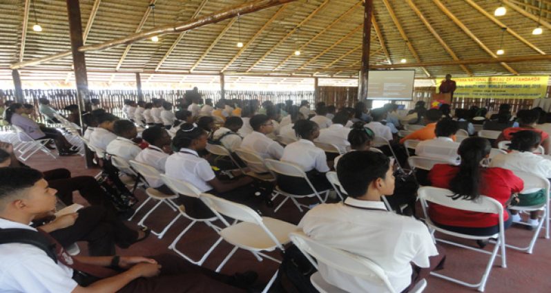 Students being addressed by a GNBS official as part of National Quality Week