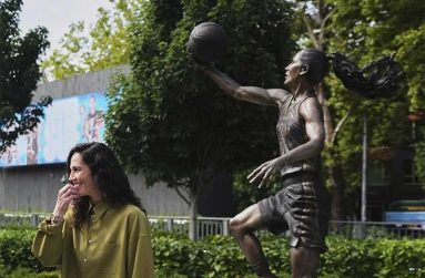 Former Seattle Storm point guard Sue Bird stands near her statue after its unveiling outside Climate Pledge Arena, Sunday in Seattle