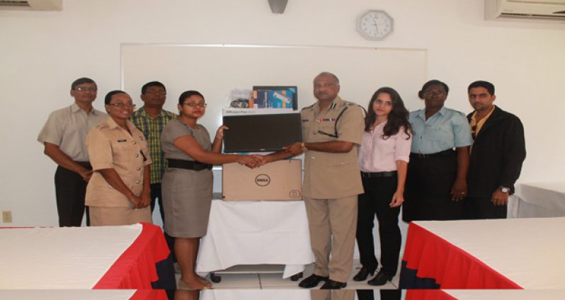 Commissioner of Police Seelall Persaud as he received the desktop computer from Innovative Mining Company official Mohini Heera, flanked by members of the Helpline’s Steering Committee