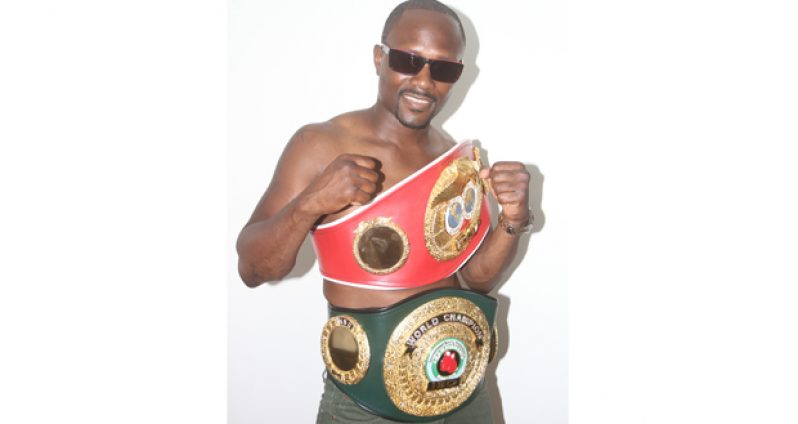 The champ is here! Guyana’s lone two-time world champion Gairy ‘Superman’ St Clair proudly displays his two belts during a visit to Chronicle Sport yesterday. (Photo by Sonell Nelson)