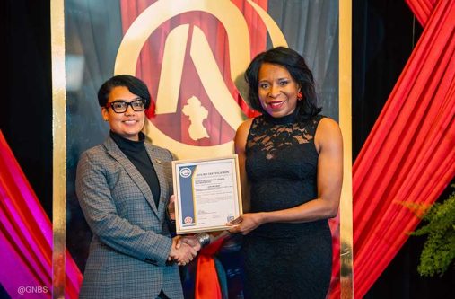 Minister of Tourism, Industry and Commerce, the Honourable Susan Rodrigues, presents the GYS 901 certificate to Avia Maria Lindie at NQA 2025