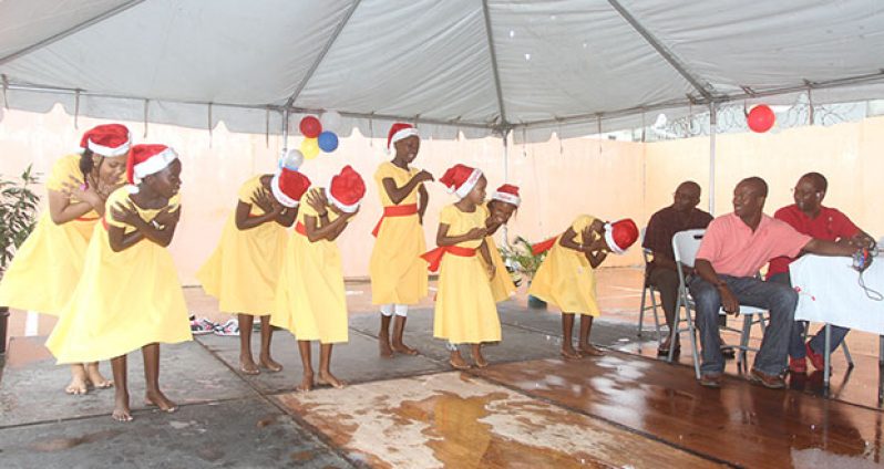 Commander Hicken and his deputy De Hearte (extreme right) are all smiles as junior dancers perform during the cultural presentation at the children’s party