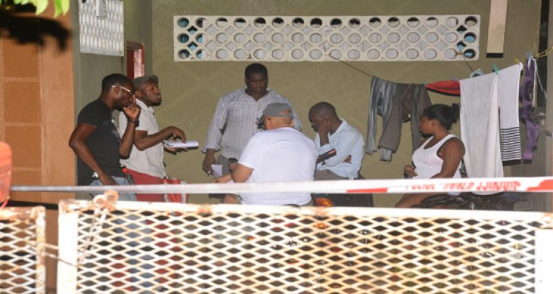Police investigators gathered in the yard where the incident occurred as they interviewed the dead man’s fiancé at extreme right