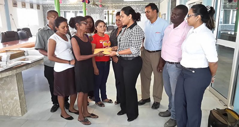 A BK International family member hands over the money to Ms  Dhanwantie Persaud