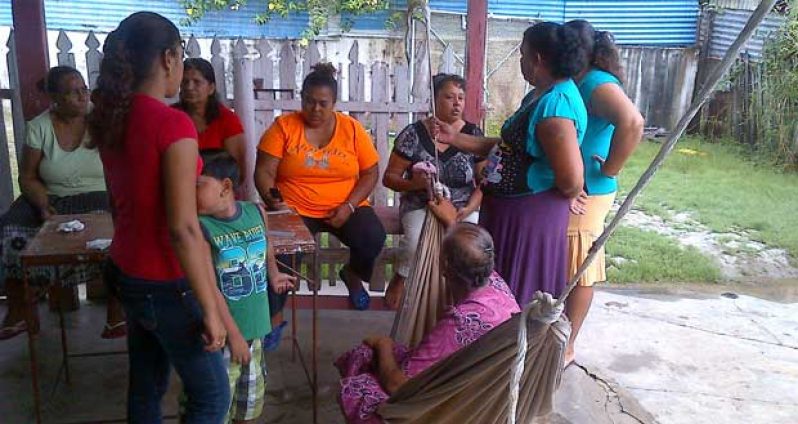 Relatives and friends surround the mother of 17-year old Danraj Latchman