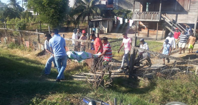 Family and friends removing the body of the dead man late yesterday