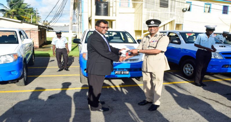 ‘Top Cop’ Mr Seelall Persaud receiving the keys to one of the vehicles from Public Security Minister, Mr Khemraj Ramjattan