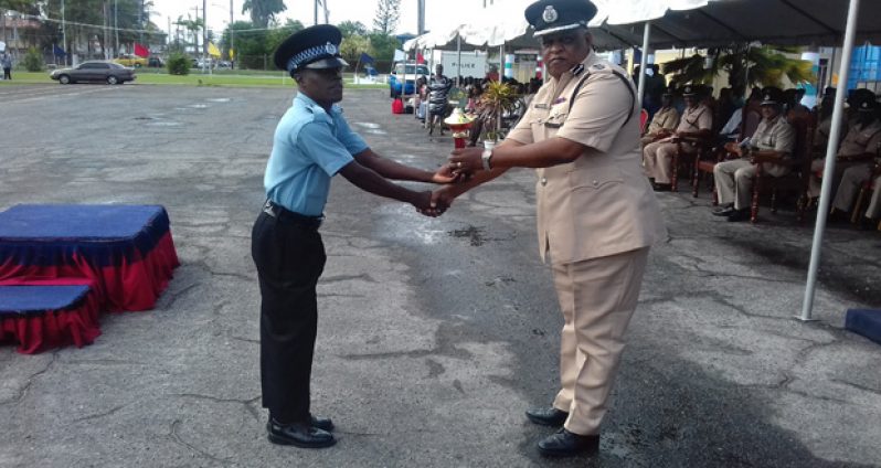 Second Runner-up Best Graduating Student, 21-year-old Police Constable Stephon Pearson, receiving his trophy from Assistant Police Commissioner, Administration, Balram Persaud