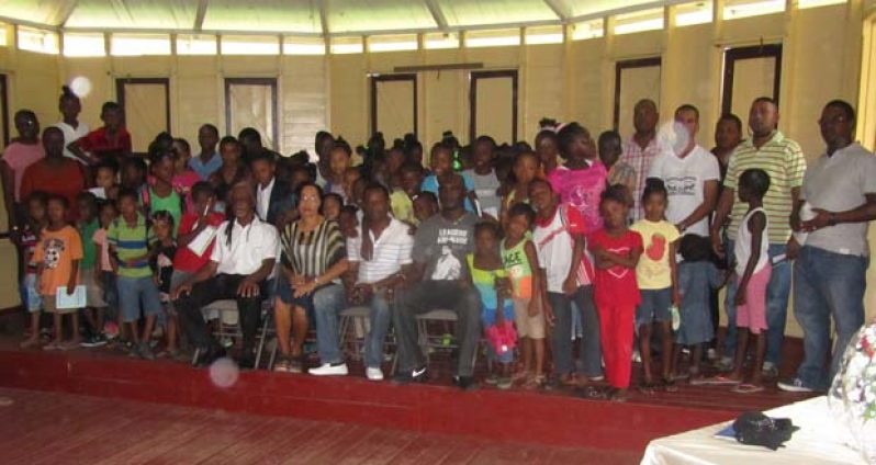 The children of the newly-formed youth group pose with  police ranks and facilitators of the group. Among those seated are St Anne’s Primary’s headmistress, Ms Melissa Isaacs (second left), and ‘A’ Division Deputy Commander, Dion Moore (right)