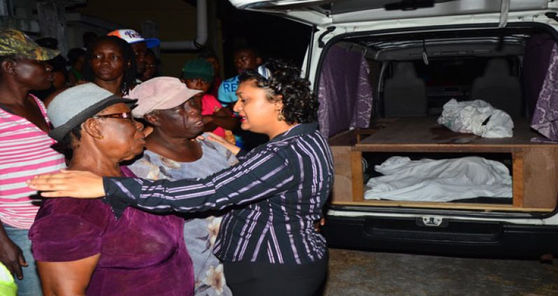 Education Minister Priya Manickchand comforts members of the Abel family last evening