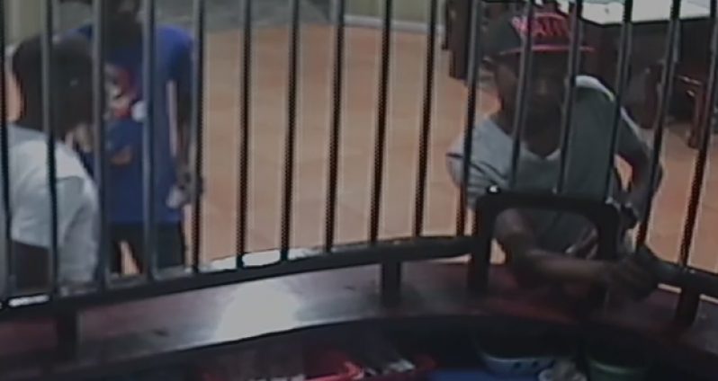 The shooter pulling the trigger of the gun to shoot the cashier