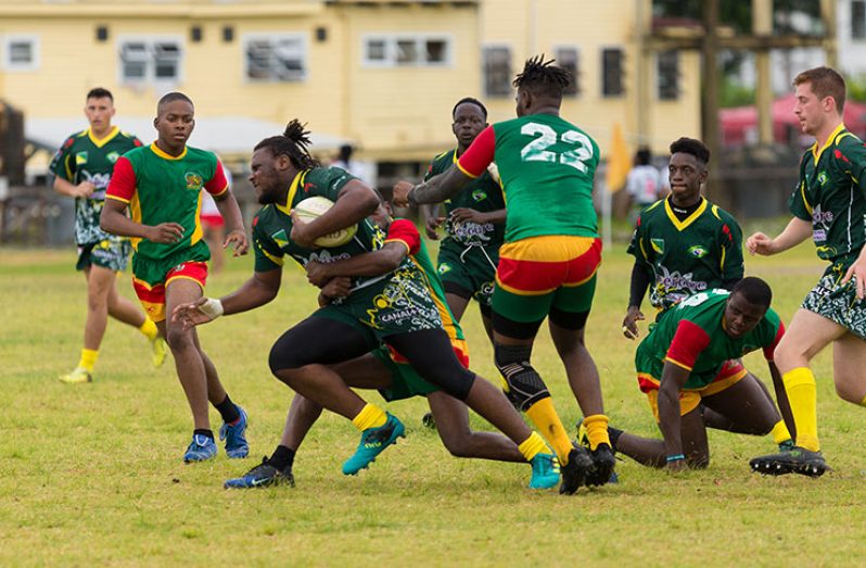 A French Guiana U-19 player tries to avoid the attention of Guyana’s U-19 ruggers. (Delano Williams photo)