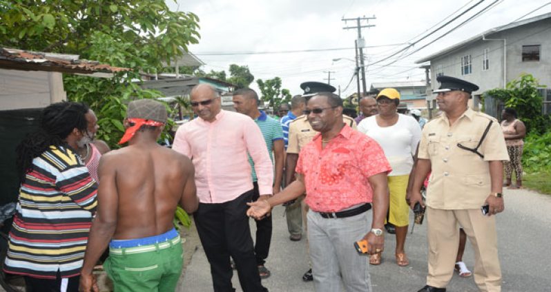 Commissioner Seelall Persaud and Commander Hicken along with other ranks conduct a walkabout in Agricola prior to commissioning a police- renovated community centre ground