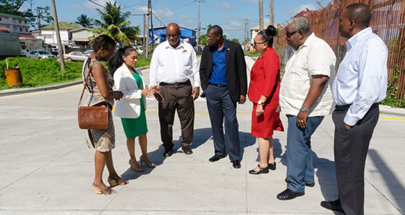 Minister of Public Infrastructure David Patterson (centre) flanked by TCL Plant Manager Mark Bender, Mayor Patricia Chase-Green and TCL officials during a discussion on the newly commissioned concrete slab technology road.