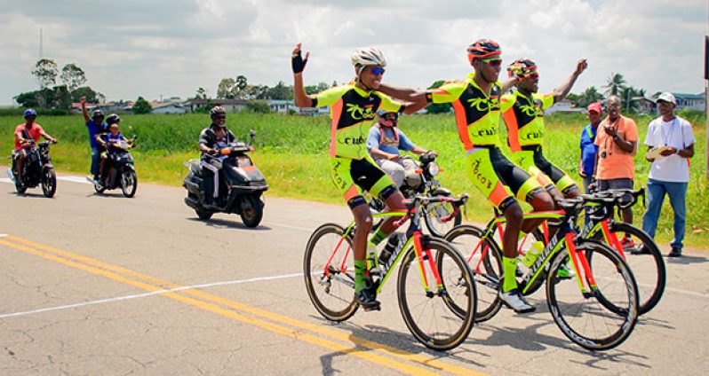 Team Coco’s team members hold hands aloft as they cross the finish line to take the top three places in the Victor Macedo Memorial 80-mile cycle road race. Race winner Stephano Husbands is at centre, while second place finisher Hamzah Eastman is at right and Mark Harris is on the left in this Samuel Maughn photo)