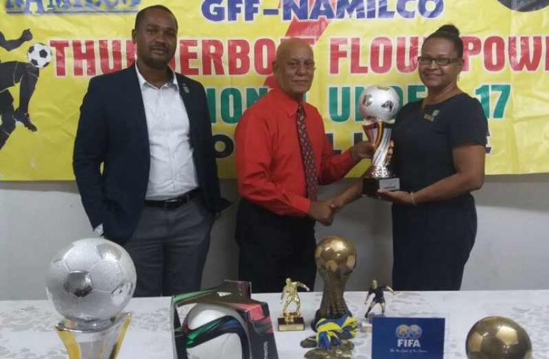 NAMILCO Marketing Consultant Hafeez Khan presents trophies to Carmel Williams (Bartica FA) in the presence of GFF president Wayne Forde