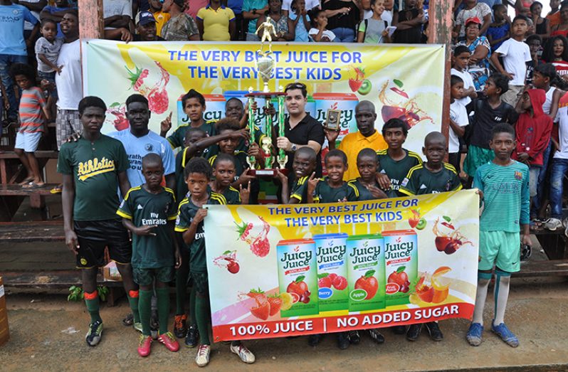 Sueria Manufacturing, Juicy Juice representative Sean Rodrigues pictured with the champions, Timehri Panthers, after handing over the trophy.