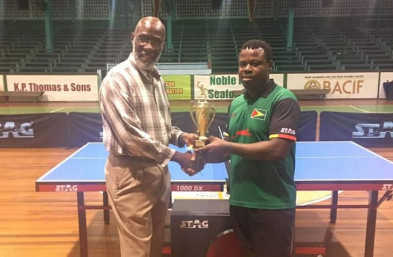 Orin Hickerson (right) collects the championship trophy from chairman of the Forbes Burnham Foundation, Vincent Alexander.