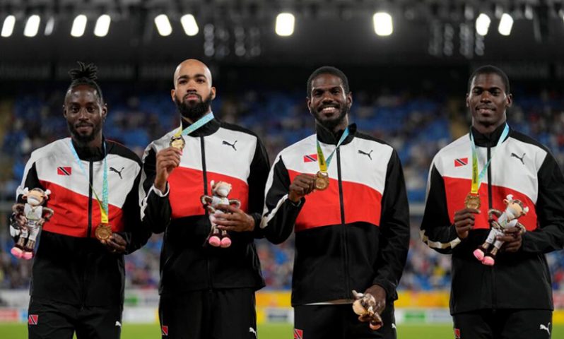 Team TT poses on the podium after winning the gold medal in the Men's 4 x 400 metres relay during the athletics competition in the Alexander Stadium at the Commonwealth Games in Birmingham, England, on Sunday. - Alastair Grant