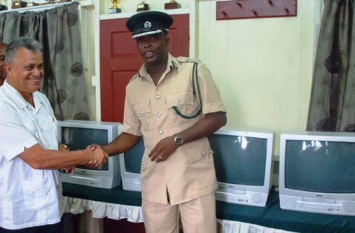 Roraima Airways CEO Captain Gerald Gouveia greets acting Director of Prisons Gladwin Samuels as he hands over the five television sets and DVD players to the Guyana Prison Service. (Photo by Delano Williams)