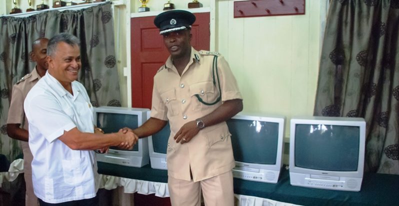 Roraima Airways CEO Captain Gerald Gouveia greets acting Director of Prisons Gladwin Samuels as he hands over the five television sets and DVD players to the Guyana Prison Service. (Photo by Delano Williams)