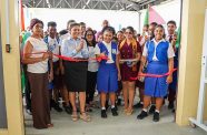 Minister of Education, Priya Manickchand, flanked by students and teachers, observes the formal ribbon cutting ceremony to commission the brand-new Practical Instruction Department (PID) at Bartica Secondary School