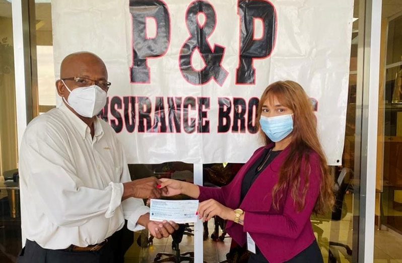 National table tennis coach and secretary of the Guyana Table Tennis Association, Linden Johnson, collects the cheque from  Urmila Shamsundar, Account Executive of P&P Insurance Brokers Guyana