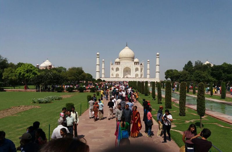 Visitors taking photographs with the Taj Mahal in the background