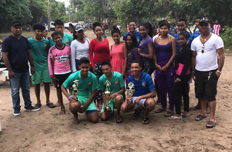 (Extreme Left) Commander Budhram with the winning football teams and their captains, trophies and other youths.