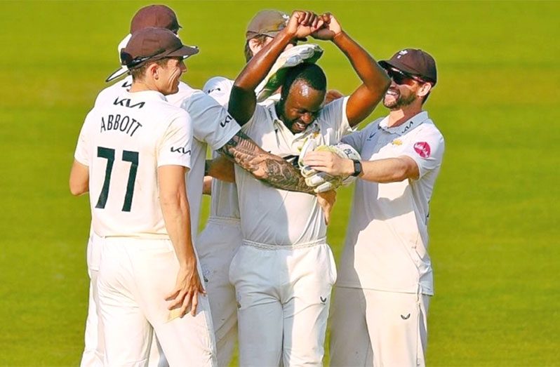 Kemar Roach being congratulated by Surrey teammates