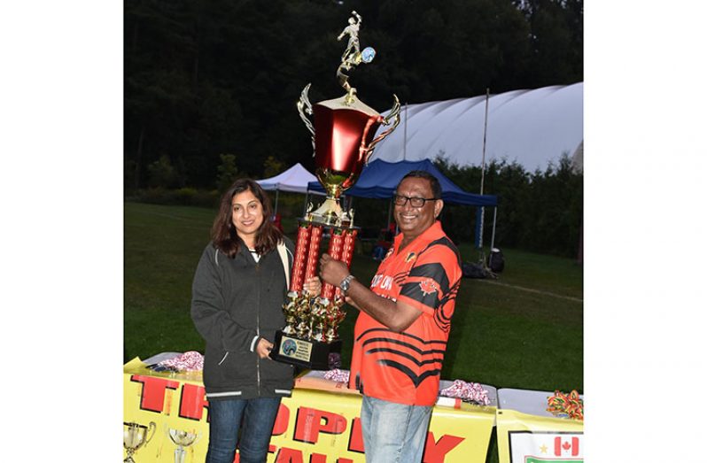 Devi Sunich, wife of Trophy Stall’s Ramesh Sunich, hands over the winning trophy to Our Own manager Teddy Hussein.