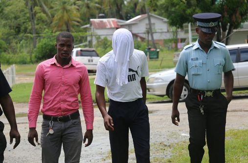 The teen accused (head covered) on his way to court on Tuesday (Photo by Delano Williams)