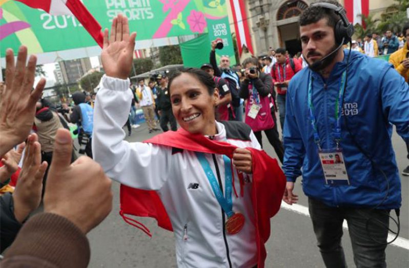 Peru's Gladys Tejeda celebrates with her gold medal and fans, following the medal ceremony after the Women's Marathon at Kennedy Park, Lima, Peru.  (REUTERS/Henry Romero)