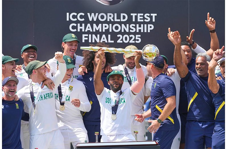 South Africa's captain Temba Bavuma holds the winner's trophy and celebrates with teammates on the podium after their win in the World Test Championship against Australia at Lord's cricket ground in London, Saturday, June 14, 2025 (AP Photo/Kirsty Wigglesworth)