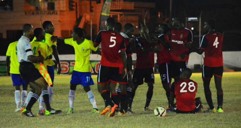 Tempers flare! Pele FC’s Gregory ‘Jackie Chan’ Richardson plays peacemaker between Jermaine Somerset and Alpha United’s Philbert Moffat.