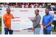 Operations Integrity Management System Coordinator at ExxonMobil Guyana, Tenesha Les Flores, makes a ceremonial presentation to FL Sport's Yusuf Ali in the presence of ExxonMobil Guyana’s Community Relations Supervisor, Ryan Hoppie at the National Stadium, Providence on Saturday
