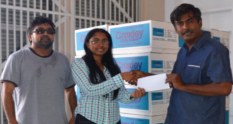 Supervisor of WJ Enterprise, Teresa Naraine (centre), presents the sponsorship to GFSCA member Petamber Maharaj in the presence of secretary of the association, Lalta Gainda.