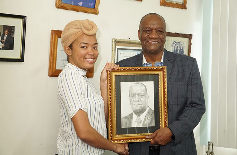 Mr. Harmon receiving the framed portrait of himself from young Shani Bellamy who undertook the project (Photo by Carl Croker)