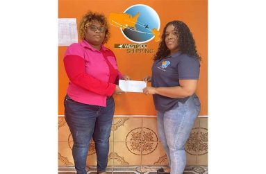Ms. Thompson of RS Sports receiving sponsorship from representative of West Side Shipping, Ms. Simone Moonsammy.