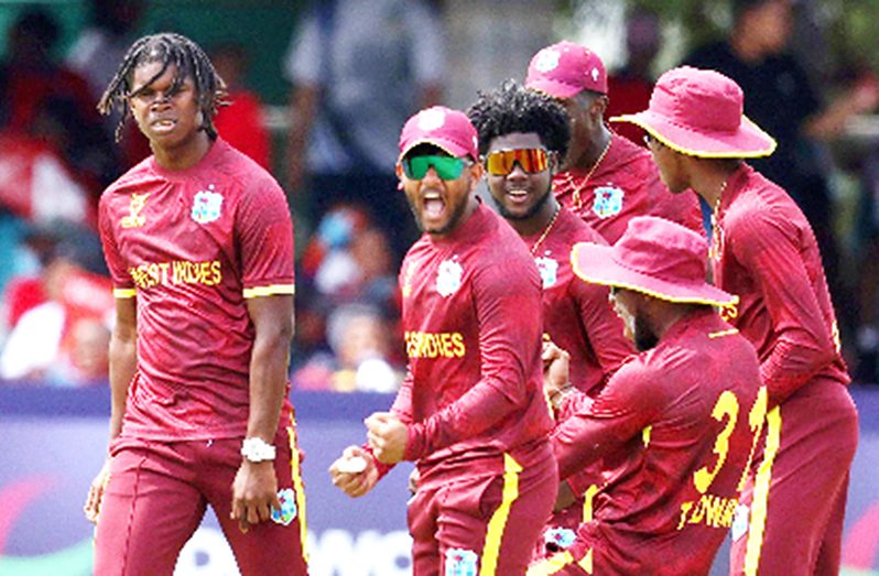 Fast bowler Isai Thorne (left) celebrates one of his two wickets with teammates (Photo courtesy ICC)