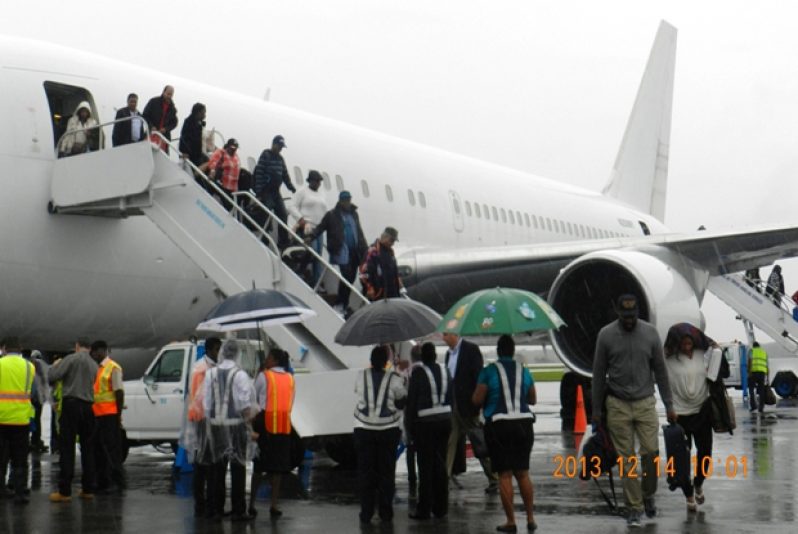 Passengers getting off the plane yesterday after it touched down at Cheddi Jagan International