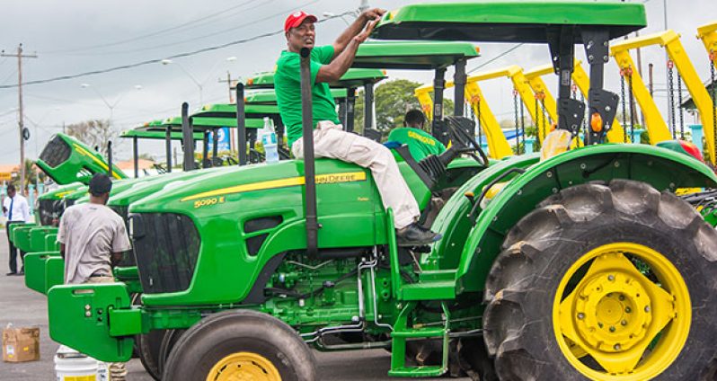 An employee of GENEQUIP applies the licence plate to one of the tractors