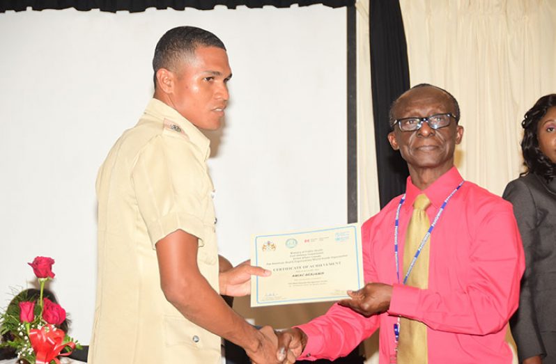One of the participants receiving his certificate from PAHO/WHO Representative, Dr. William Adu-krow (Adrian Narine photo)