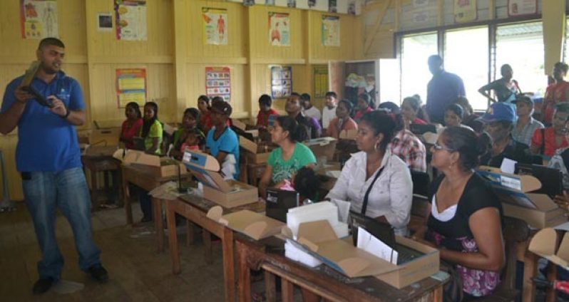 A representative of the One Laptop Per Family (OLPF) Secretariat conducting a training session at the Bush Lot Secondary School during the Region 5 laptop distribution exercise.