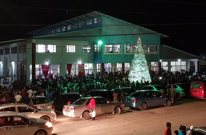 Residents gathered around the lit Christmas tree