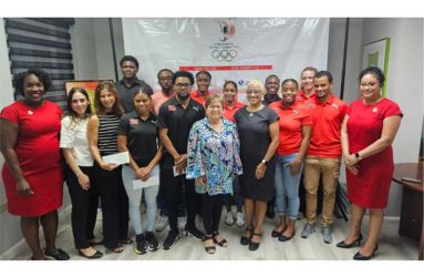 Trinidad and Tobago athletes and representatives share a photo after collecting their monetary rewards for medalling at the Central American and Caribbean (CAC) Games in Santo Domingo